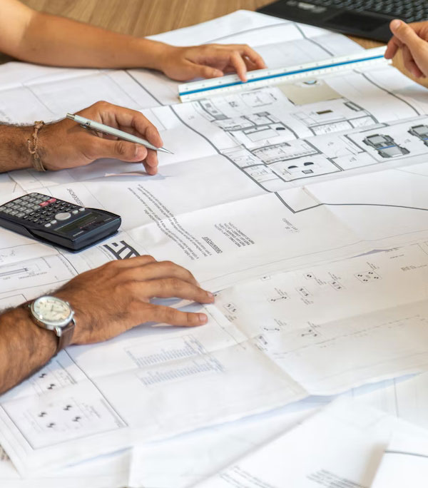 Planning document with detailed architectural drawings displayed in the foreground.